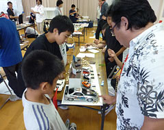 Pupils of Kaneshi Elementary School work under professionals to create models of their dream shop