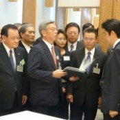 Okinawan leaders hand a petition to Prime Minister Abe requesting the easing of the base-hosting burden