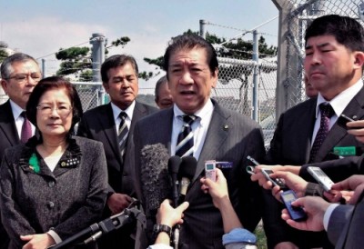 Okinawa City Mayor Sachio Kuwae (front row, center) and Naha Mayor Mikiko Shiroma (front row, left) speak to the press after engaging in protest action on March 15 in front of Camp Foster in Kitanakagusuku 