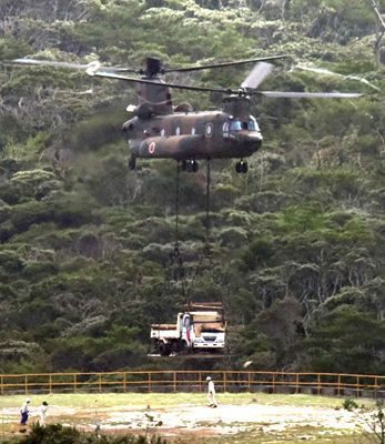 A JSDF CH-47 transport helicopter carries a large vehicle used for helipad construction in the U.S. military’s Northern Training Area on September 13 at 9:59 a.m. in Takae, Higashi Village (photograph taken by Futoshi Hanashiro) 