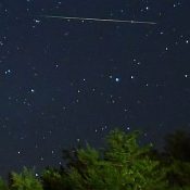 Arrows of light visible in the summer night sky